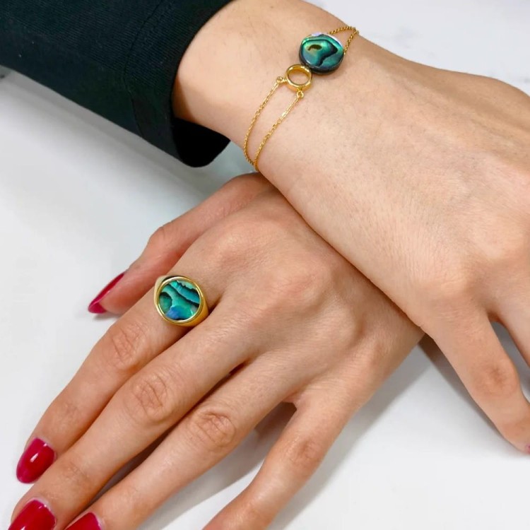 Sygnet z muszlą abalone na dłoni - srebrny pierścionek pozłacany z okrągłym kamieniem płaskim. Przykład noszenia