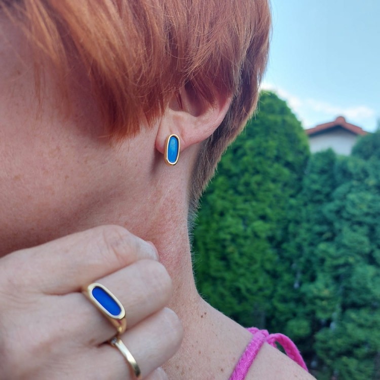 Ovale pierścionek i kolczyki - przykład noszenia - srebrna pozłacana biżuteria z kobaltowo niebieskim tytanem. Owalny minimalistyczny kształt pierścionka podkreśla subtelny charakter kolczyków.