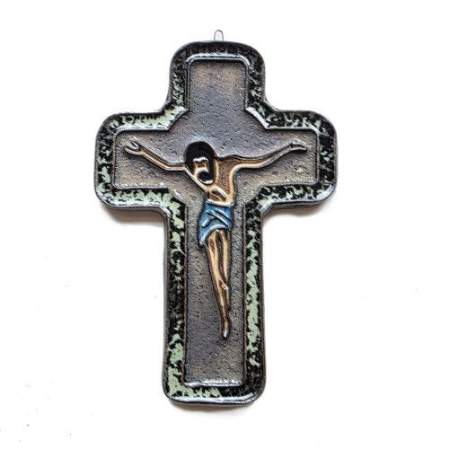 Ceramiczny krzyż, surowy w wyrazie, do powieszenia pasyjka, ciemne metalizowane szkliwo tła i otok nakrapiany