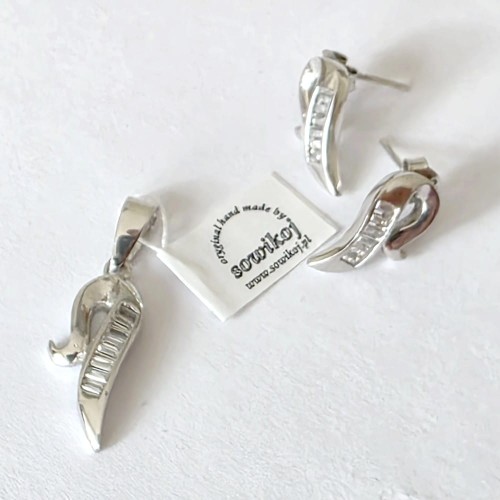 Srebrna biżuteria kolczyki i wisiorek w kształcie podwiniętych wstążek z podłużnymi cyrkoniami